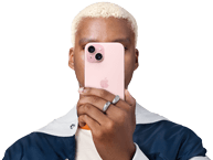 Eine Person hält sich ein iPhone 15 vors Gesicht, um ihre Identität zu verbergen